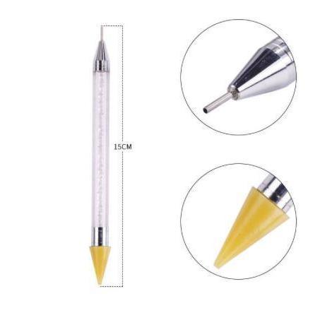 Dual tip jewel picker wax pen for rhinestones and nail art
Close-up of wax tip jewel picker tool
Jewel picker pen in use with rhinestones and gems